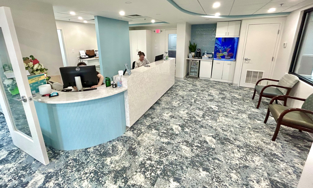 Harte Dental Image of reception area waiting room. Blue office and relaxed environment with front desk. Voted Best Dentist in Milton MA accepting new patients